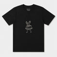 Load image into Gallery viewer, La Bailarina black T-shirt laid flat with the cream dancing-figure motif centred on the chest
