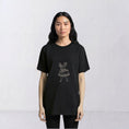 Load image into Gallery viewer, Close front view of the La Bailarina embroidered motif on a black T-shirt
