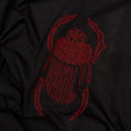 Bild in Galerie-Betrachter laden, Angled close-up of red scarab embroidery on the black Gordina Scarab T-shirt.