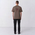 Afbeelding laden in Galerijviewer, Back view of a model wearing the Gordina The Scarab grey T-shirt with burgundy scarab embroidery.