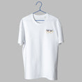 Load image into Gallery viewer, A white t-shirt on a blue wire hanger against a light grey background. It features a small embroidered design on the left chest of a pair of eyes looking over yellow wire-rimmed glasses, topped with a thick, scribbled black unibrow.