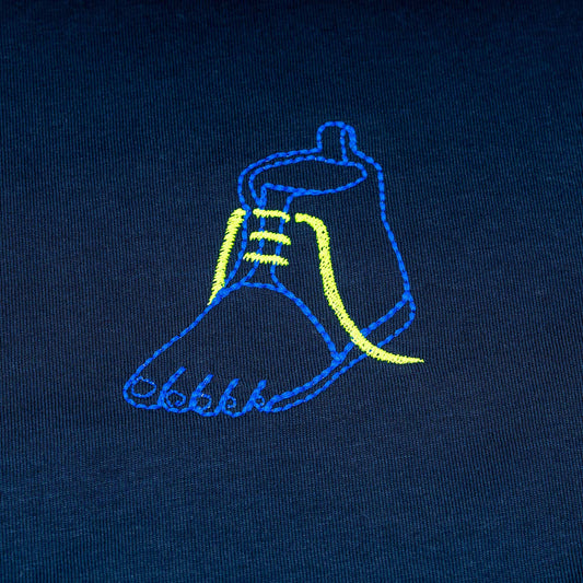 Close-up of white organic cotton t-shirt with blue and green embroidered shoe illustration, Gordina