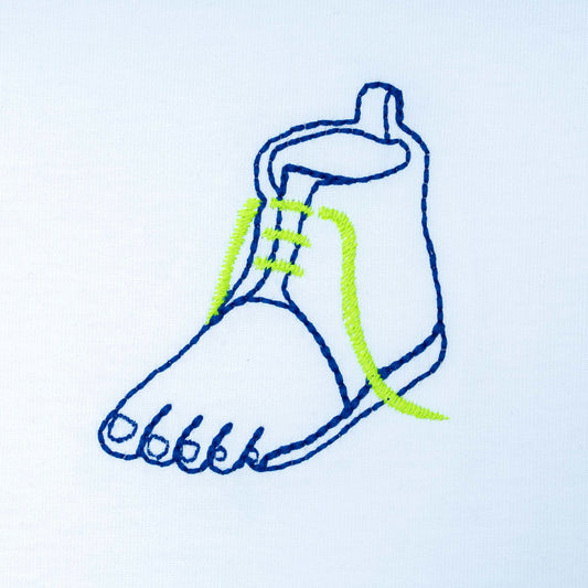 Close-up of white organic cotton t-shirt with blue and green embroidered shoe illustration, Gordina