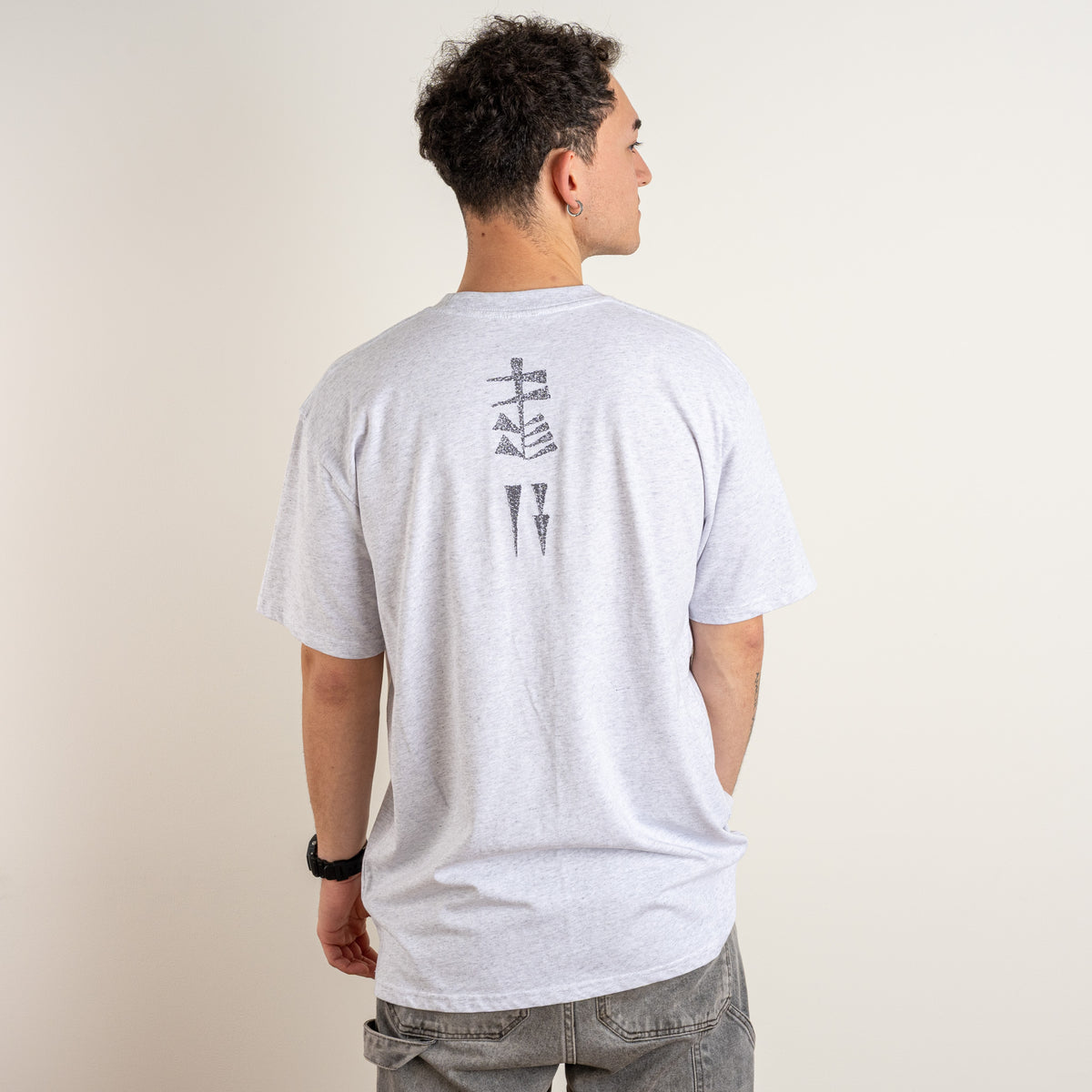 Back view of the Gordina Garden and Water T-shirt in Marble Grey with vertical charcoal cuneiform-inspired embroidery.