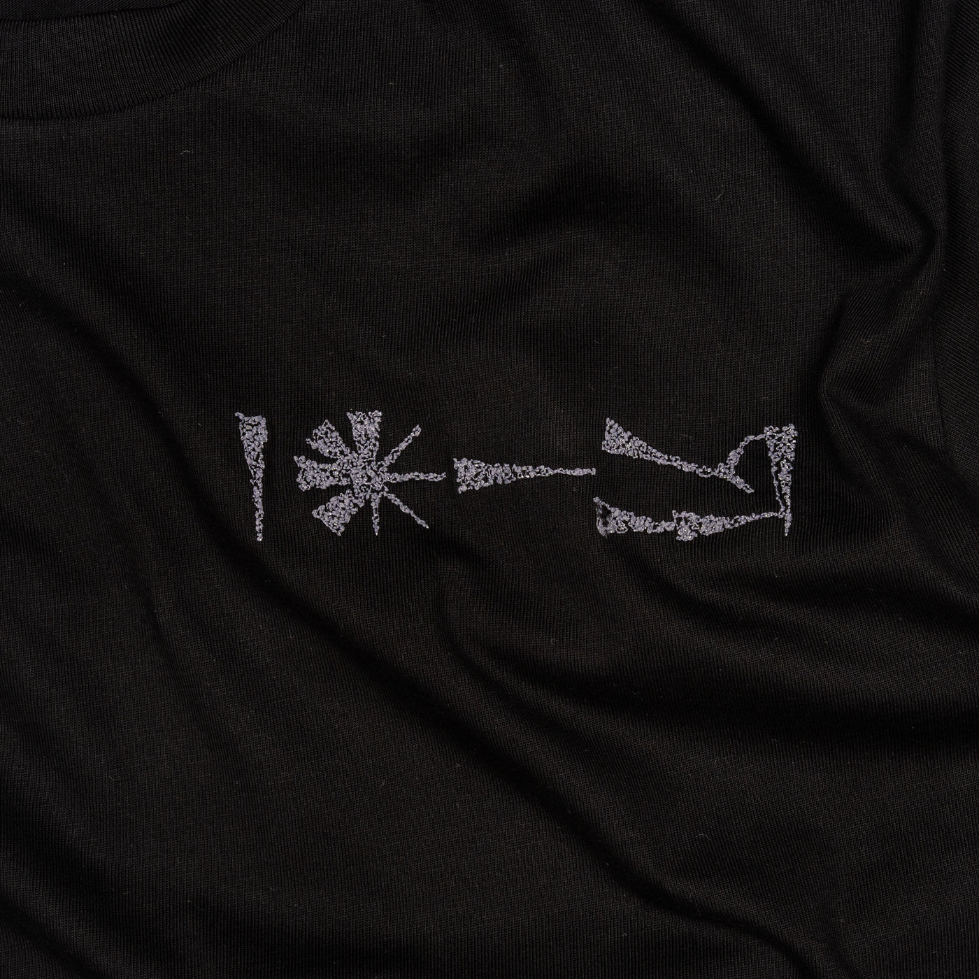 Close-up of embroidery detail on Undeciphered T-shirt