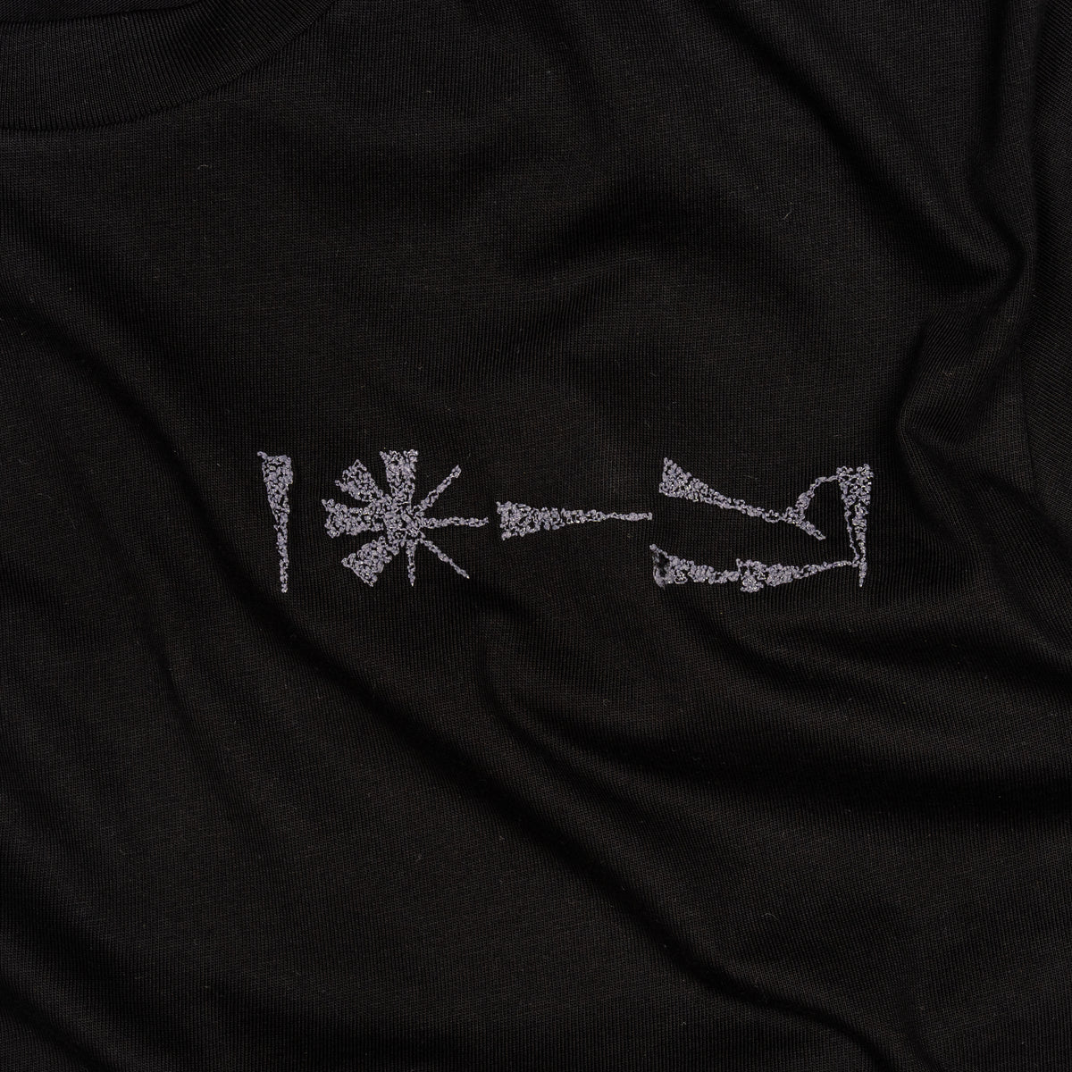 Close-up of embroidery detail on Undeciphered T-shirt