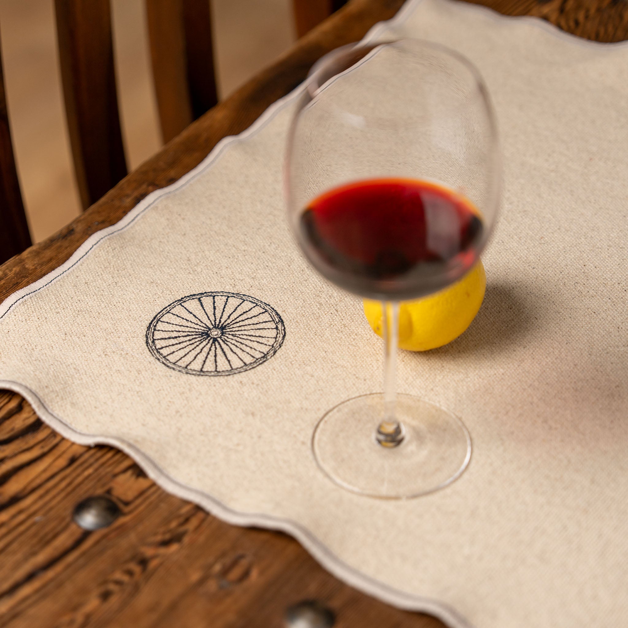 “Gordina beige cotton placemat with embroidered wheel motif – handcrafted table textile”