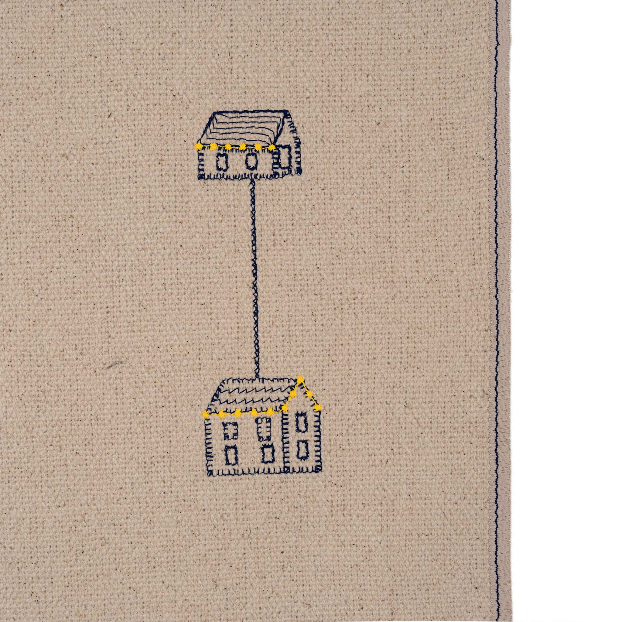 Embroidered design of a house and lamp on beige fabric