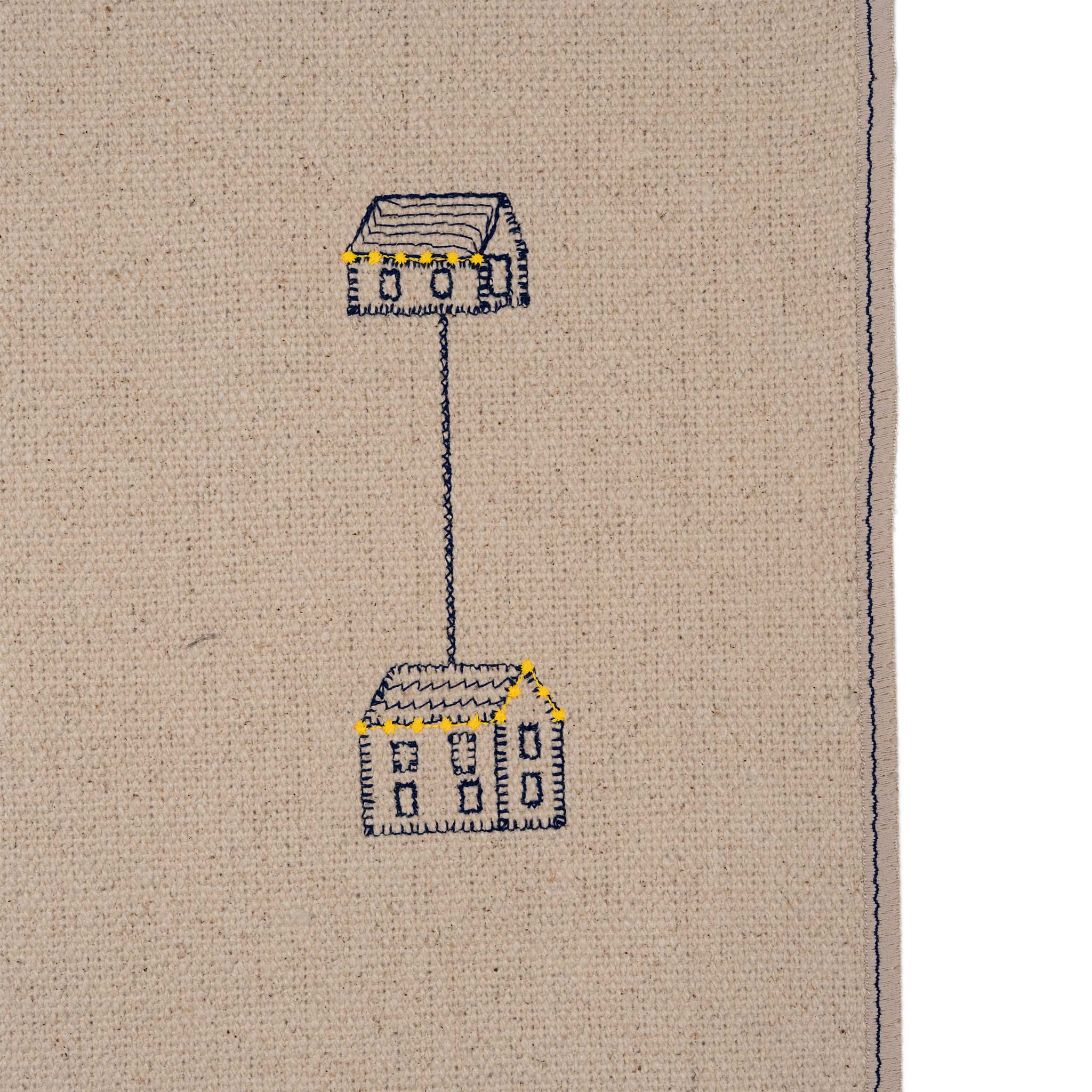 Set of four embroidered cotton placemats with connected house motifs, celebrating family, home, and craftsmanship.
