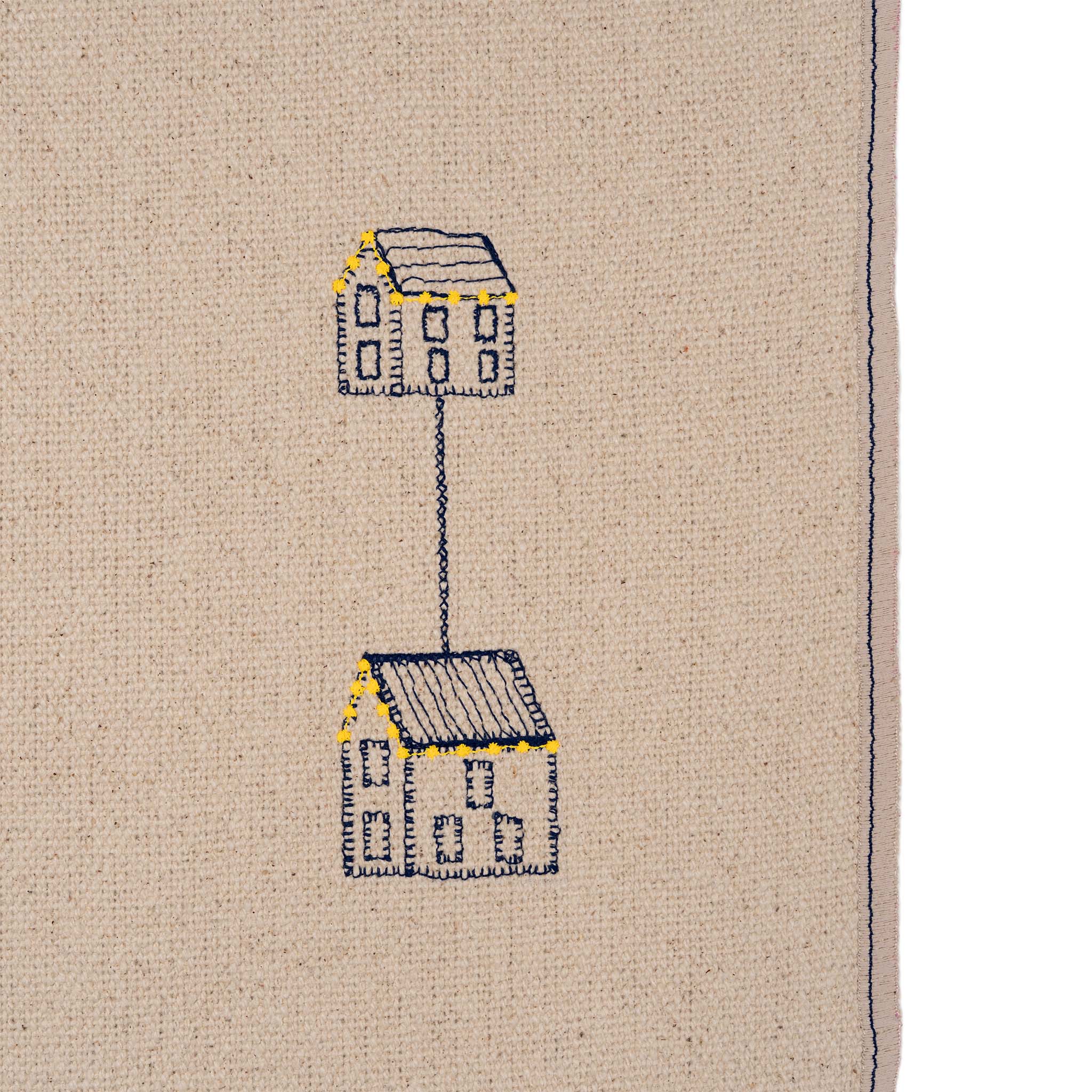Set of four embroidered cotton placemats with connected house motifs, celebrating family, home, and craftsmanship.
