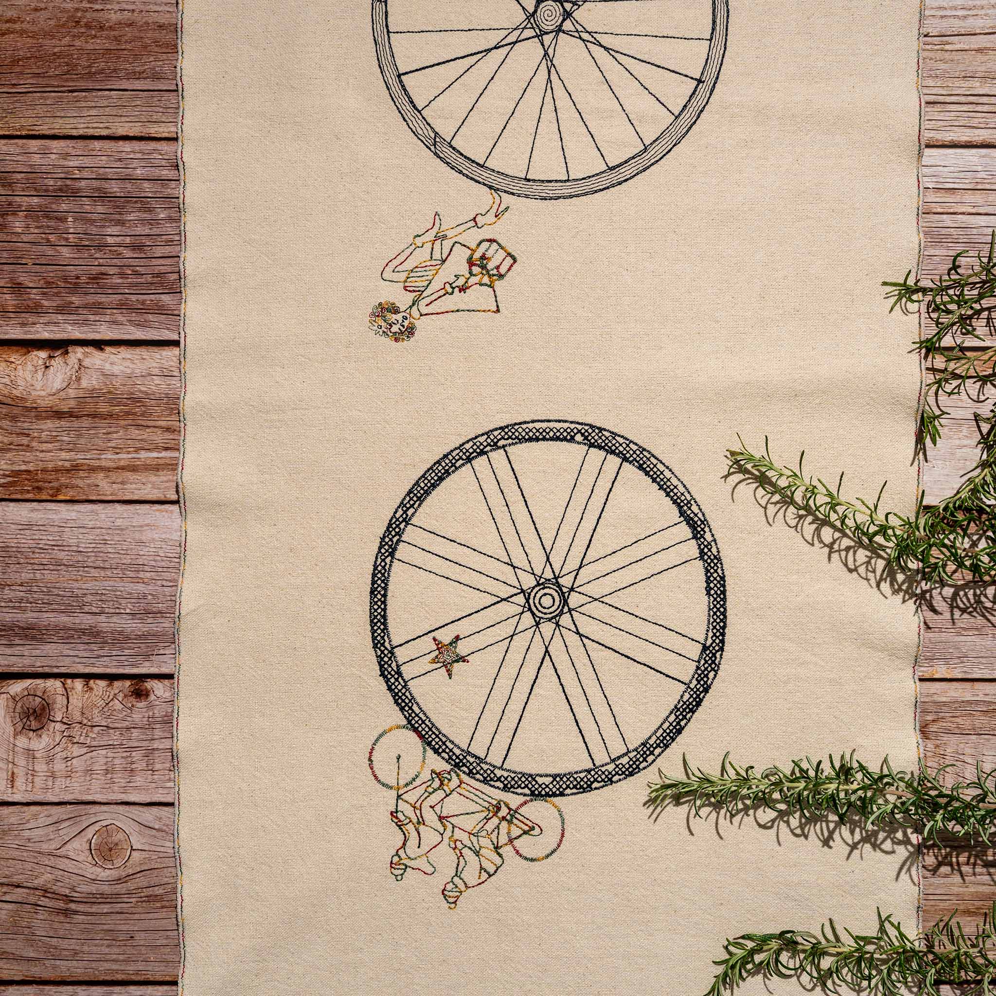 Handmade embroidered cotton table runner with bicycle motif, designed in the Netherlands for winter gatherings.
