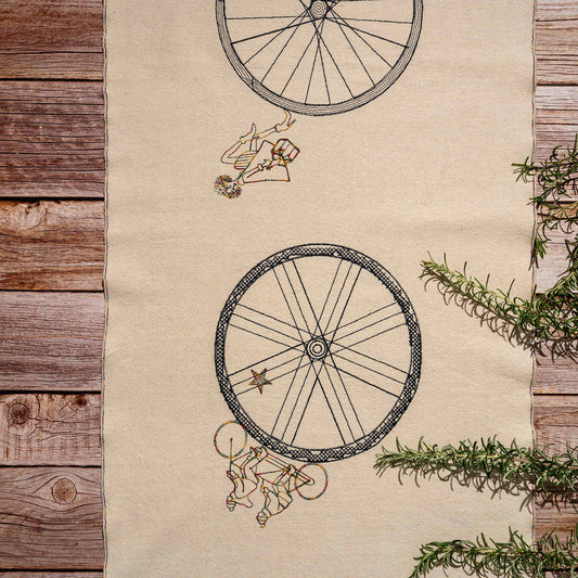 Handmade embroidered cotton table runner with bicycle motif, designed in the Netherlands for winter gatherings.
