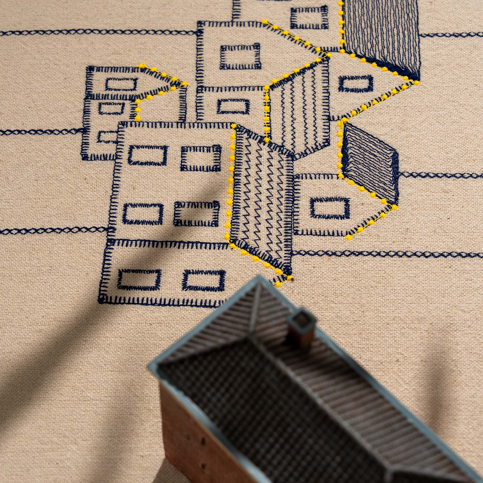 Handmade embroidered cotton tablecloth featuring connected houses, designed to evoke warmth and togetherness.
