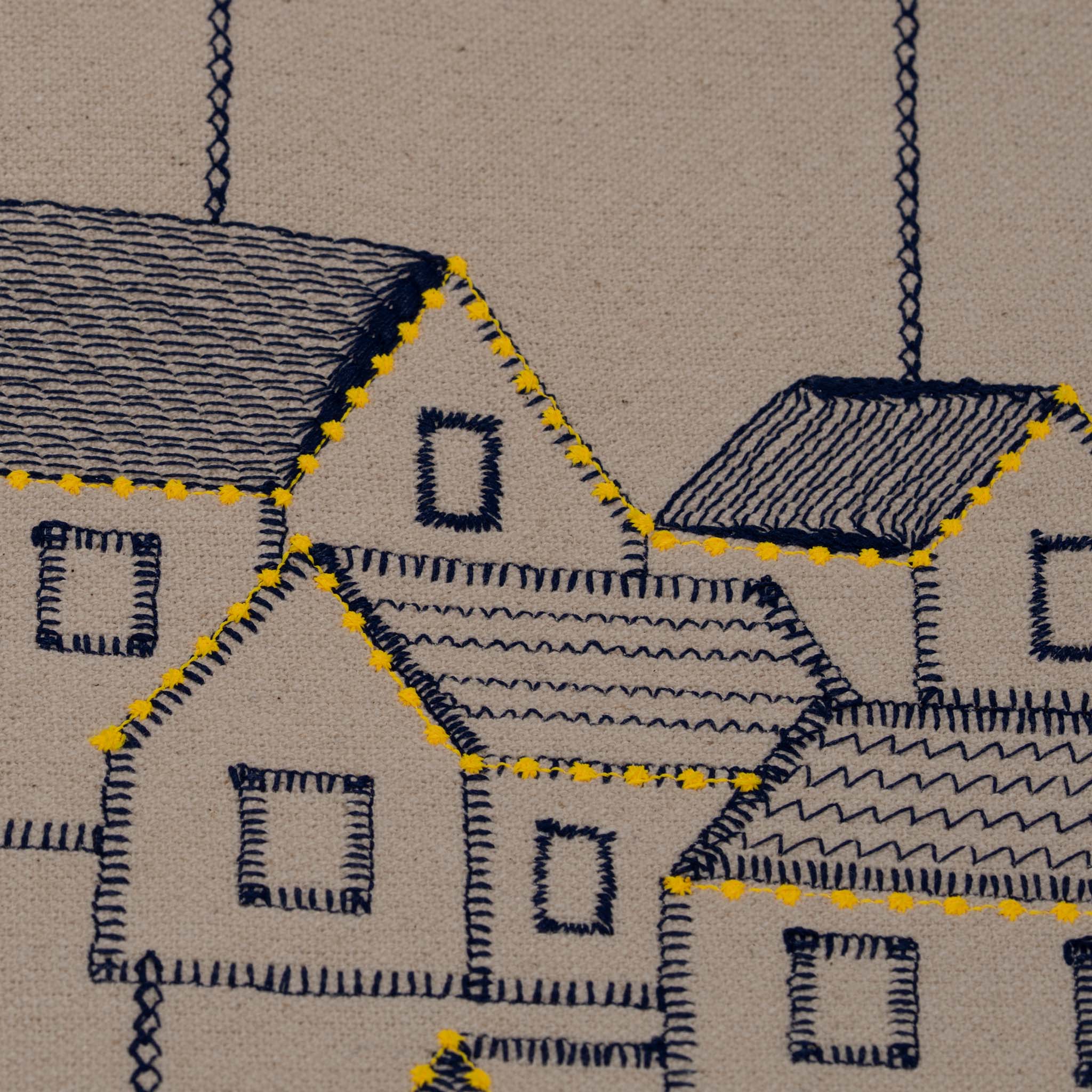 Handmade embroidered cotton tablecloth featuring connected houses, designed to evoke warmth and togetherness.
