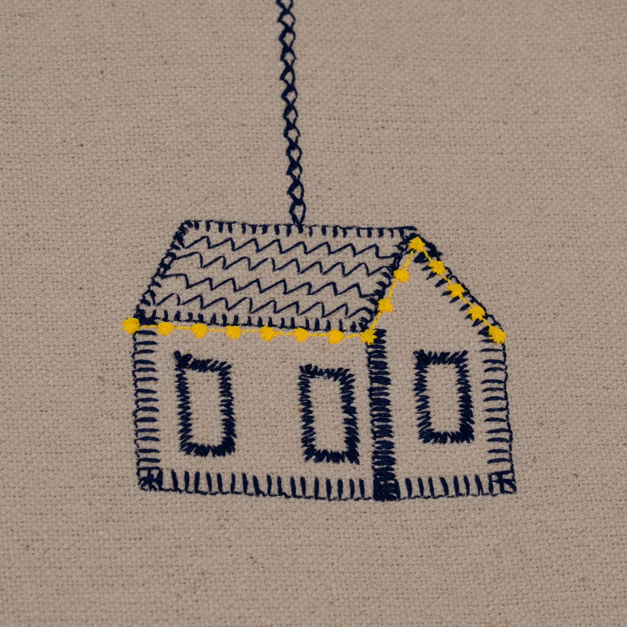 Handmade embroidered cotton tablecloth featuring connected houses, designed to evoke warmth and togetherness.