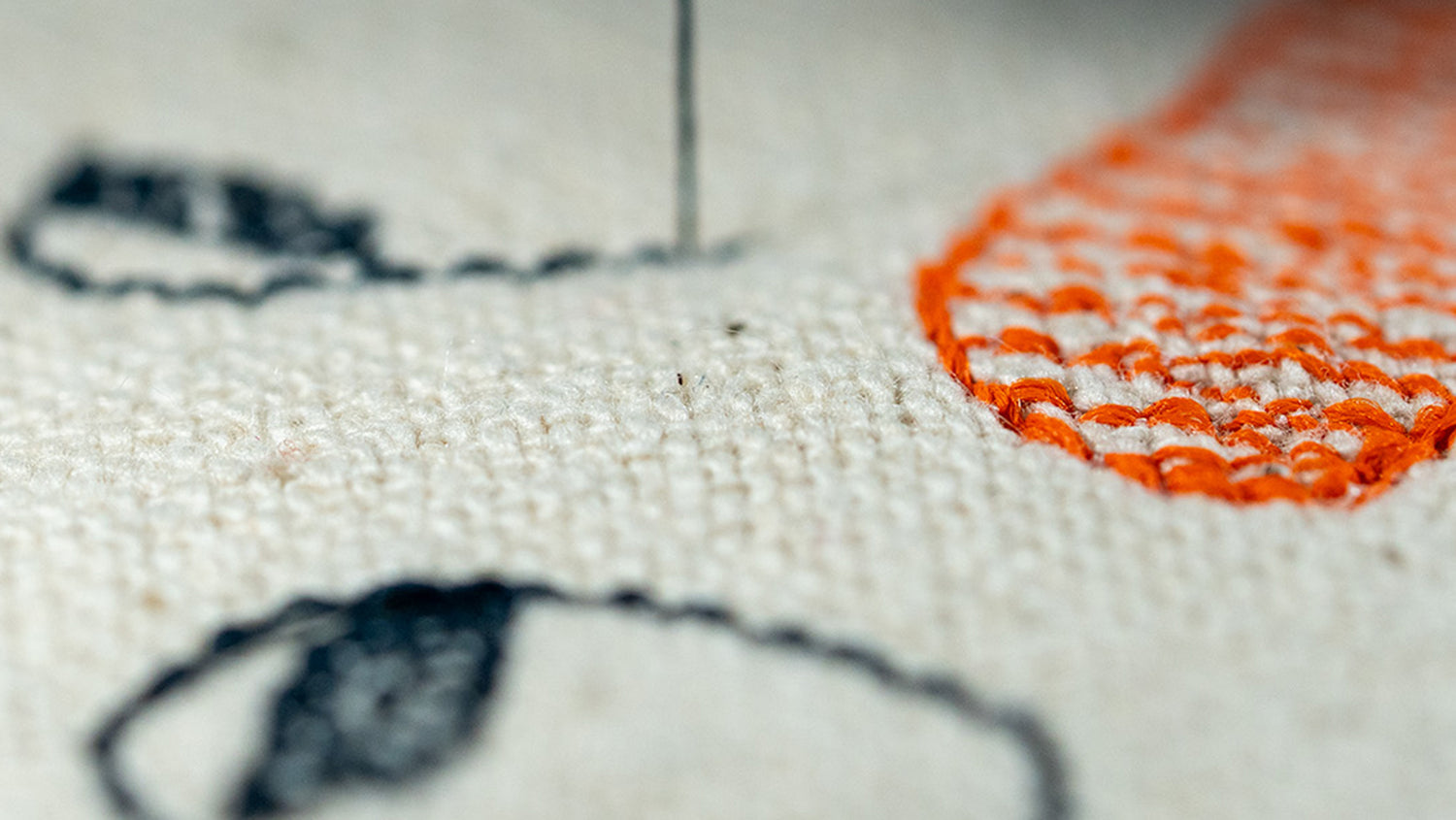 Detail of Gordina embroidered cotton fabric in warm tones, showcasing craftsmanship and handmade texture.

