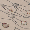 Load image into Gallery viewer, Handmade embroidered cotton tablecloth with festive light bulb design, crafted in the Netherlands for holiday gatherings.

