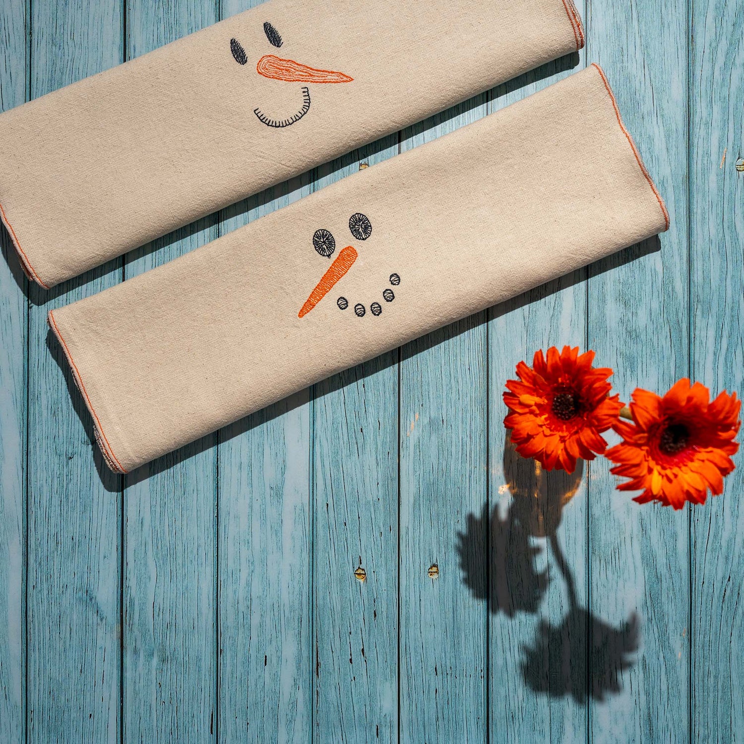 Chemin de table en coton brodé avec motif de bonhomme de neige, capturant des moments joyeux d’hiver et de Noël.
