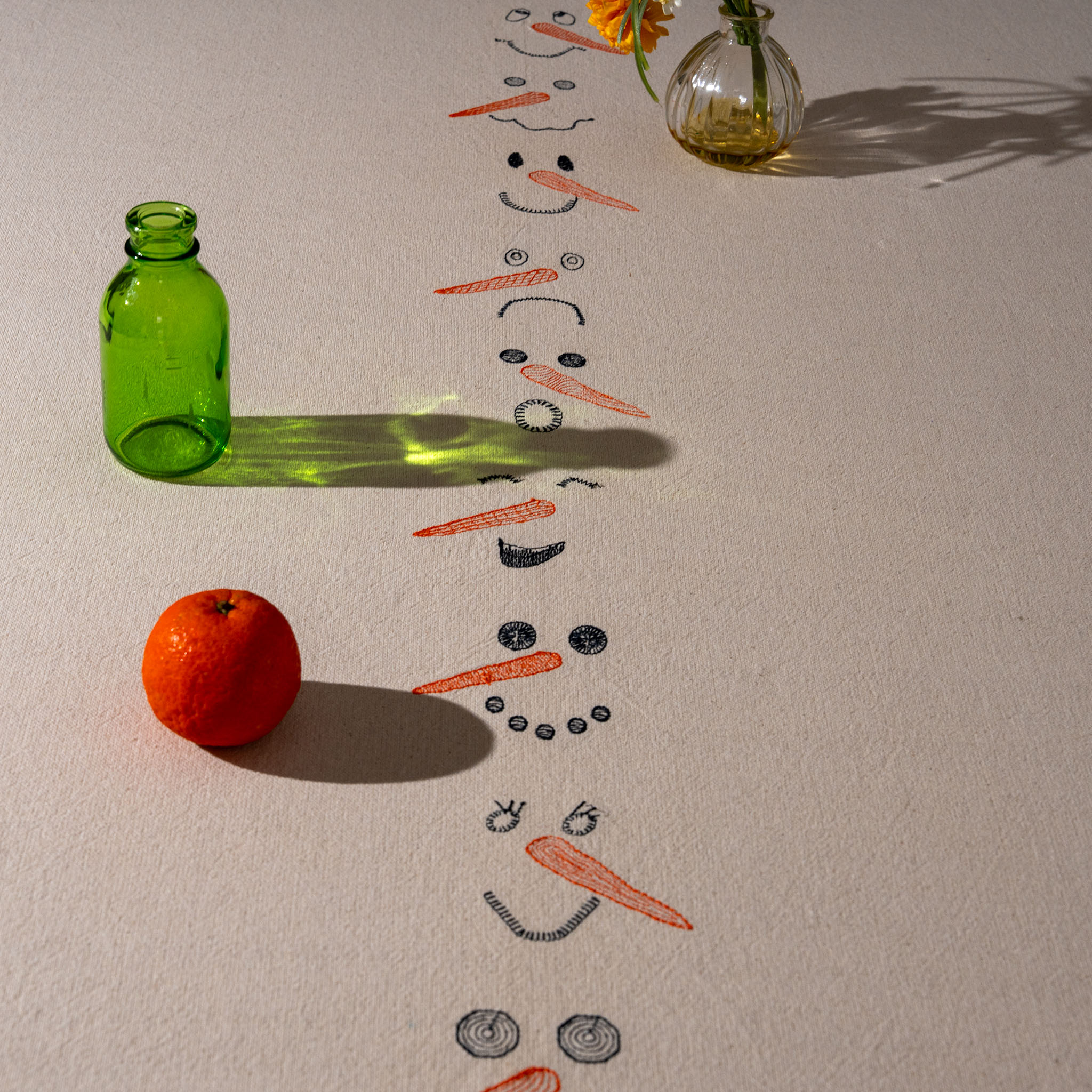 Winter-inspired embroidered cotton tablecloth with snowman motif, symbolizing childlike joy and family moments.
