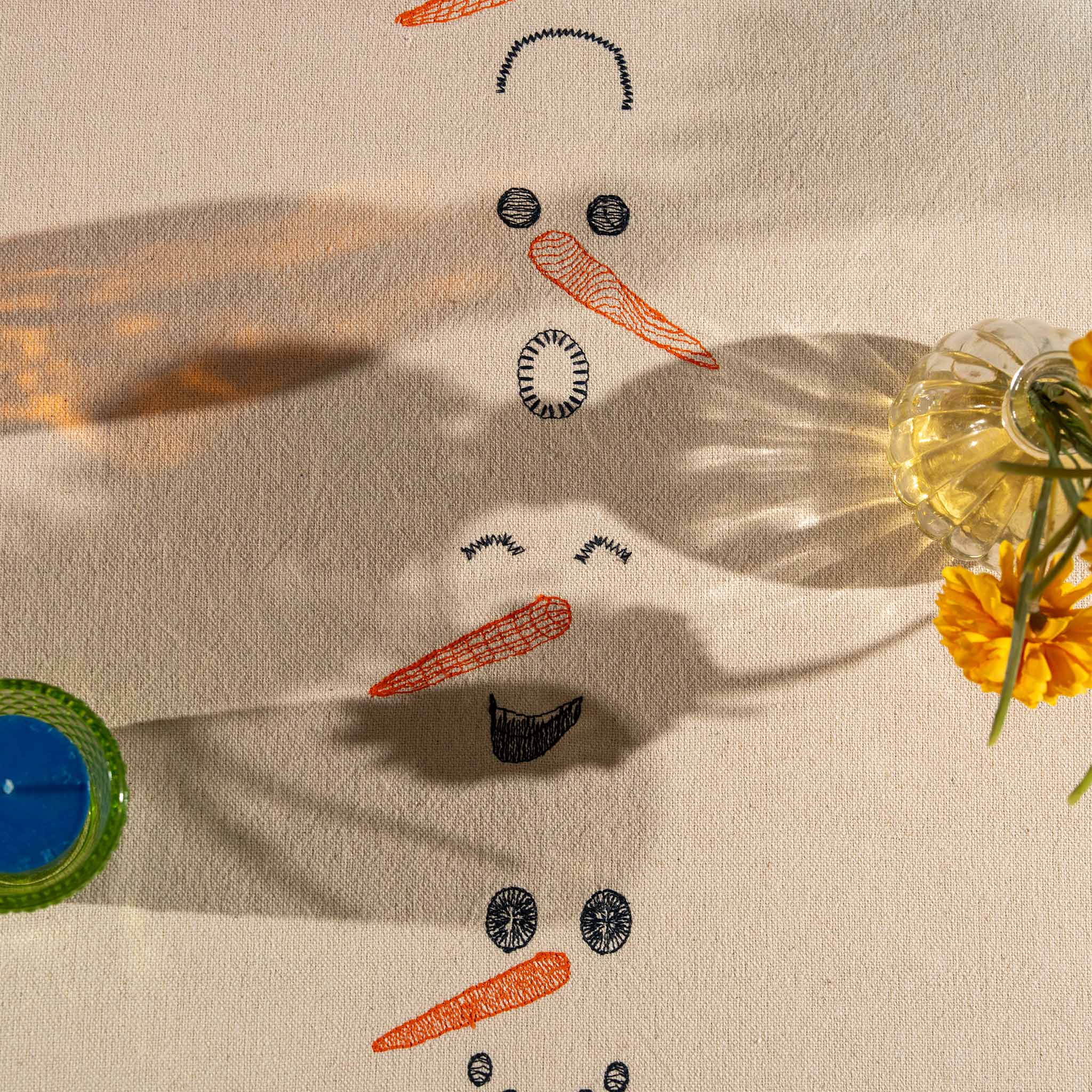 Winter-inspired embroidered cotton tablecloth with snowman motif, symbolizing childlike joy and family moments.

