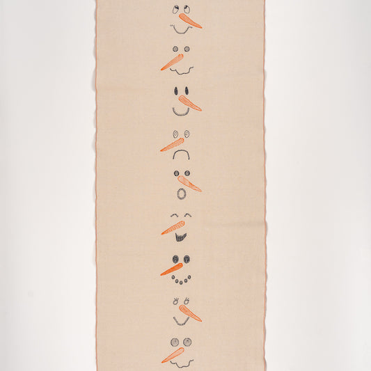 Embroidered cotton table runner with snowman design, capturing joyful winter and Christmas moments.
