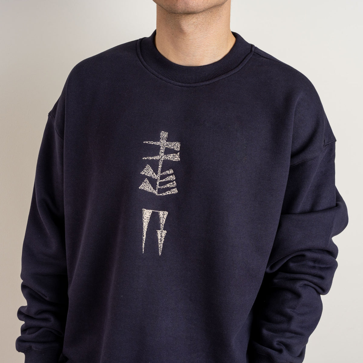 Close-up of Garden and Water embroidery on Gordina ink blue crewneck sweatshirt