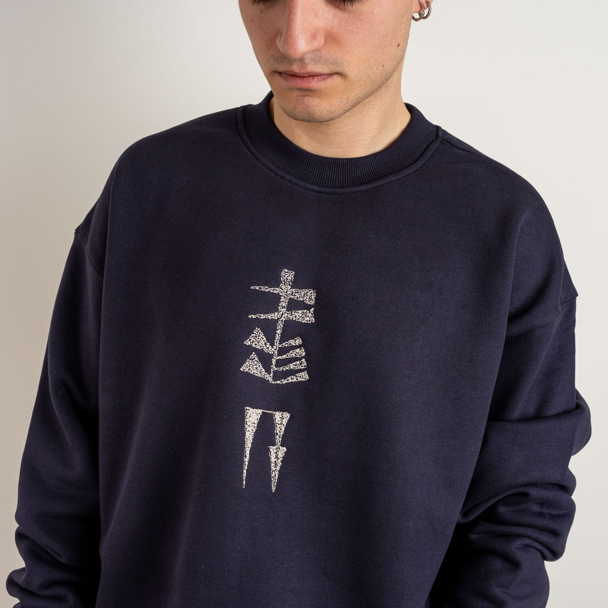 Detailed view of vertical Garden and Water motif embroidered on ink blue cotton sweatshirt