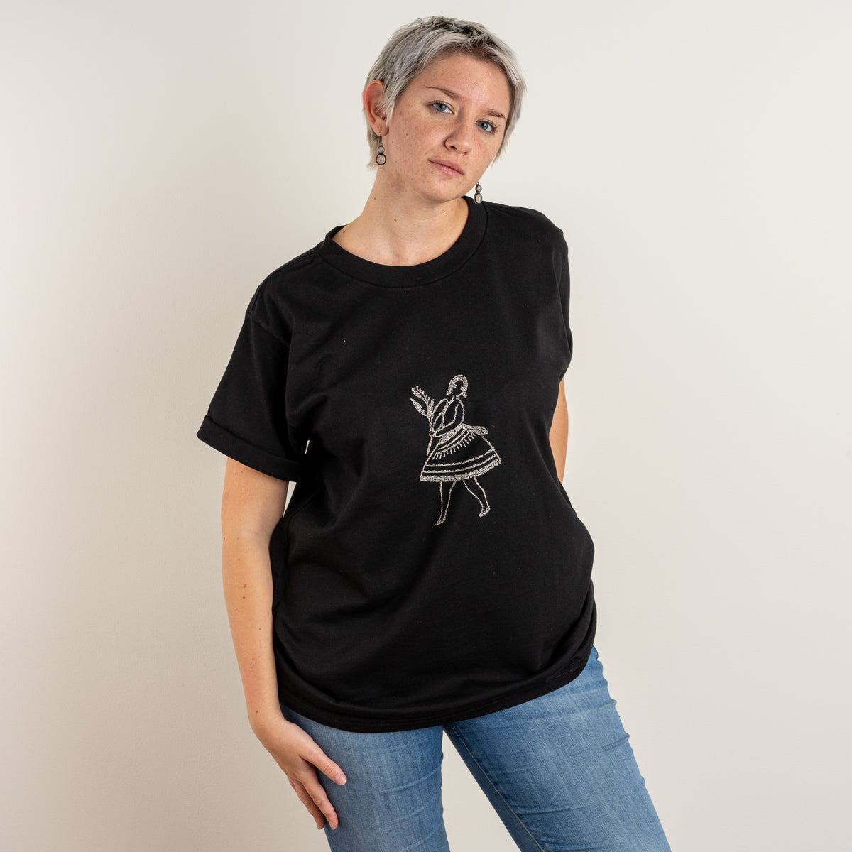 Three-quarter front view of Gordina's Black La Bailarina women's T-shirt with cream dancer embroidery.