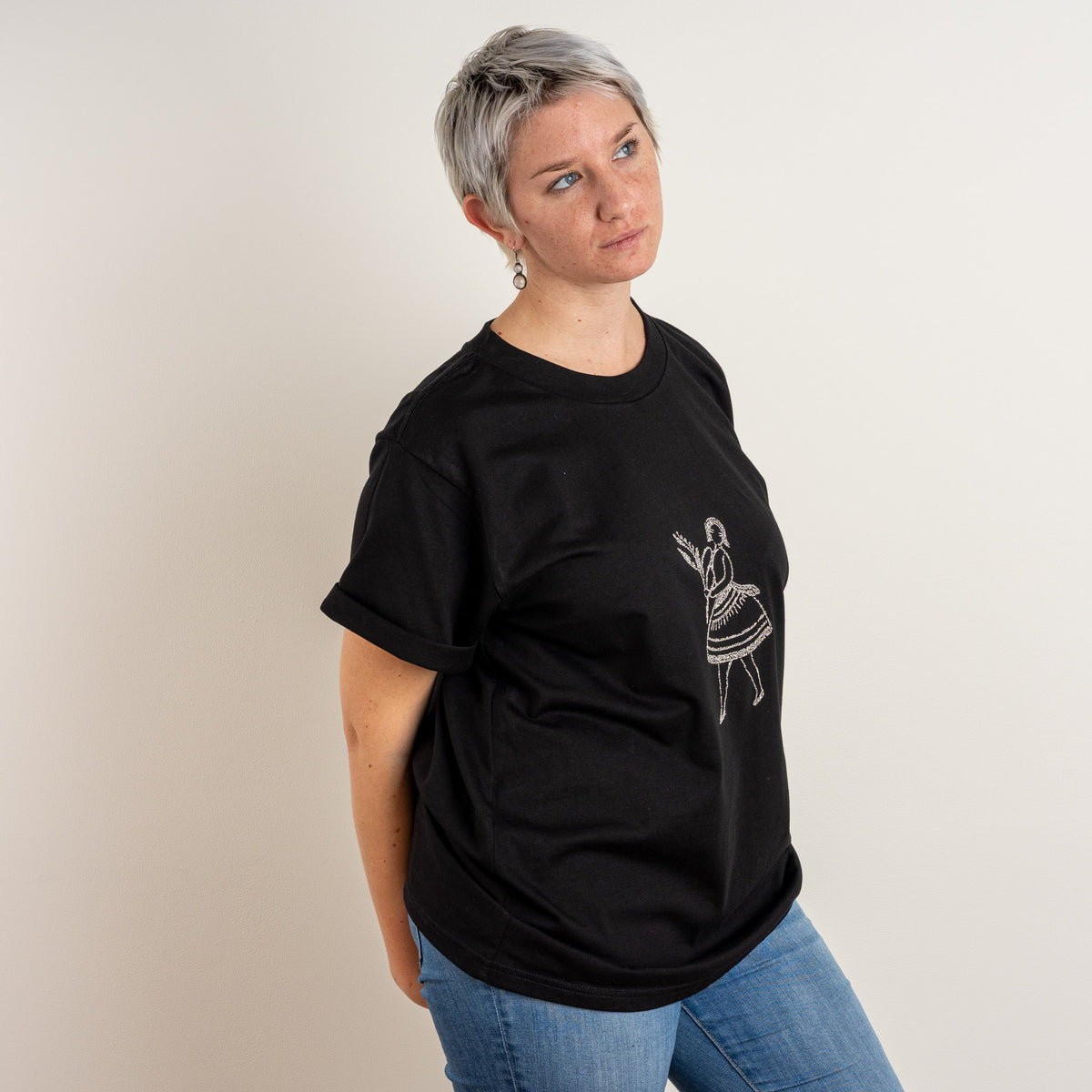 Side front view of the Black La Bailarina women's T-shirt with cream embroidered dancer.
