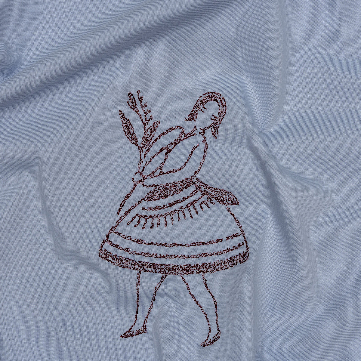 Close-up of individual burgundy stitches in the La Bailarina embroidery on powder cotton