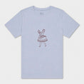 Load image into Gallery viewer, La Bailarina powder T-shirt laid flat with the burgundy dancing-figure motif centred on the chest
