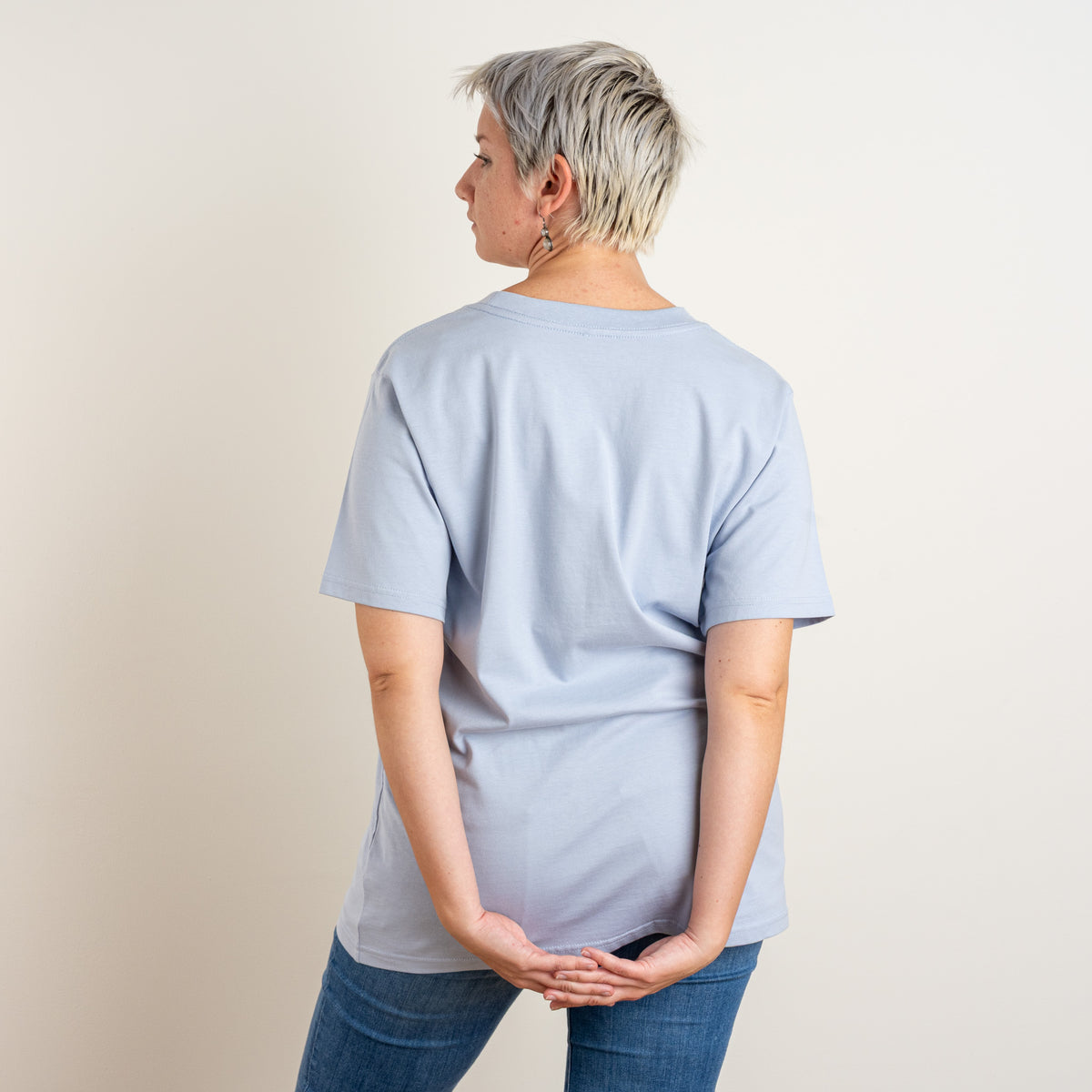 Back view of a woman wearing Gordina’s Powder La Bailarina T-shirt; the back is plain without embroidery.