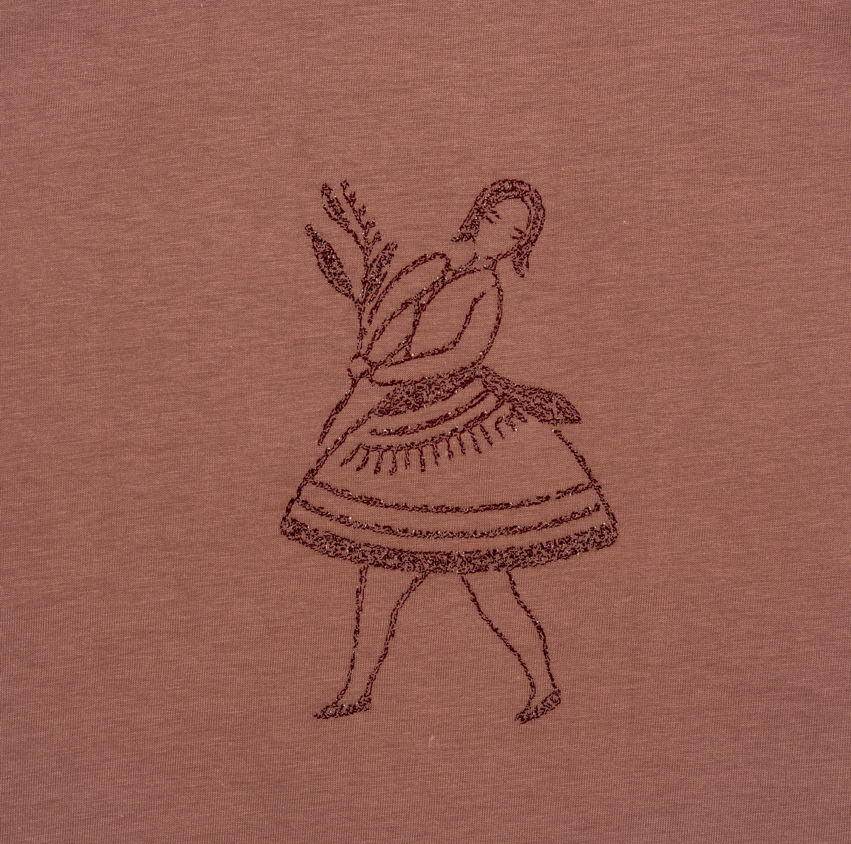 Close-up of the dancer’s embroidered skirt and fringe on the La Bailarina terracotta T-shirt