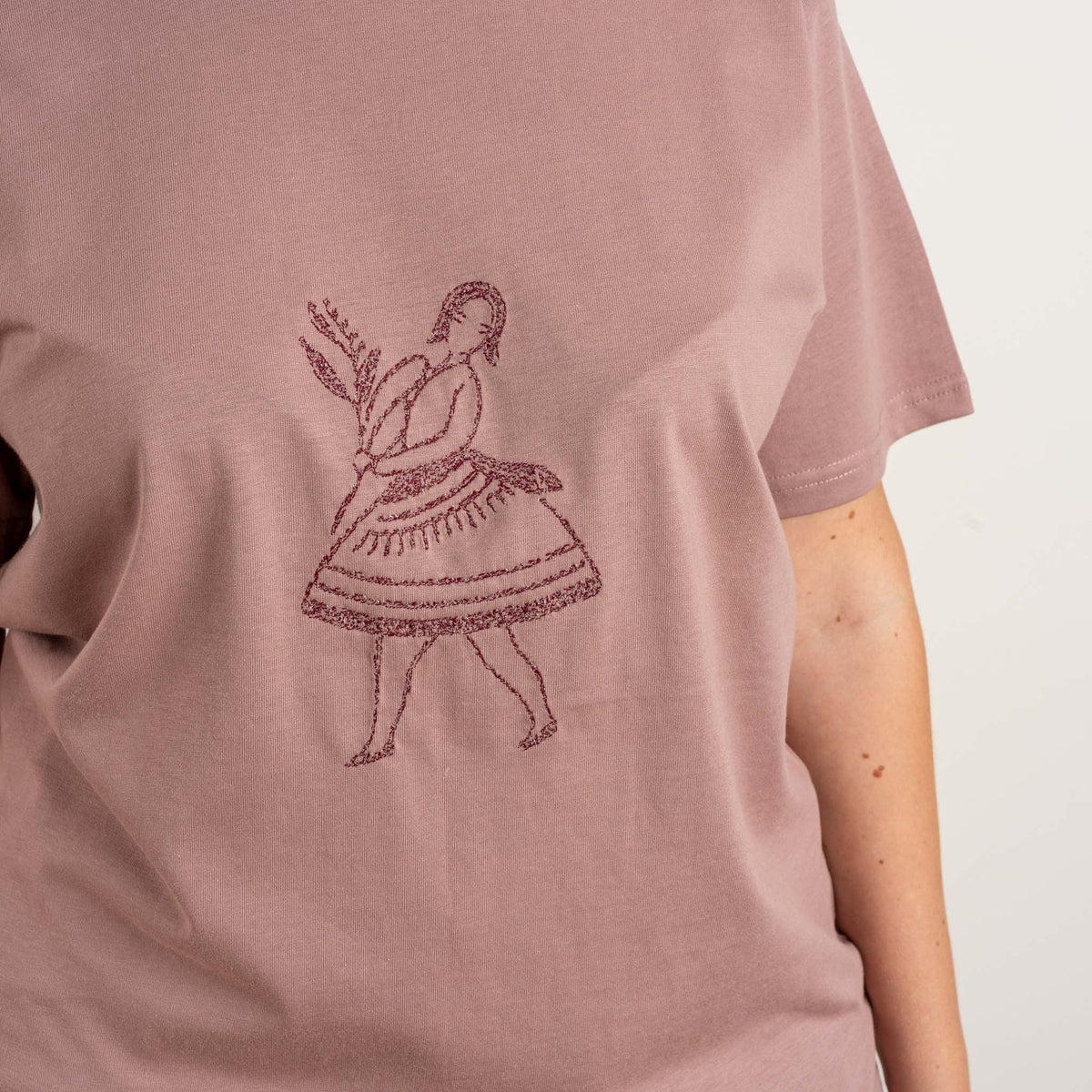 Detailed view of the dancer motif embroidered on the front of the Terracotta cotton T-shirt for women.