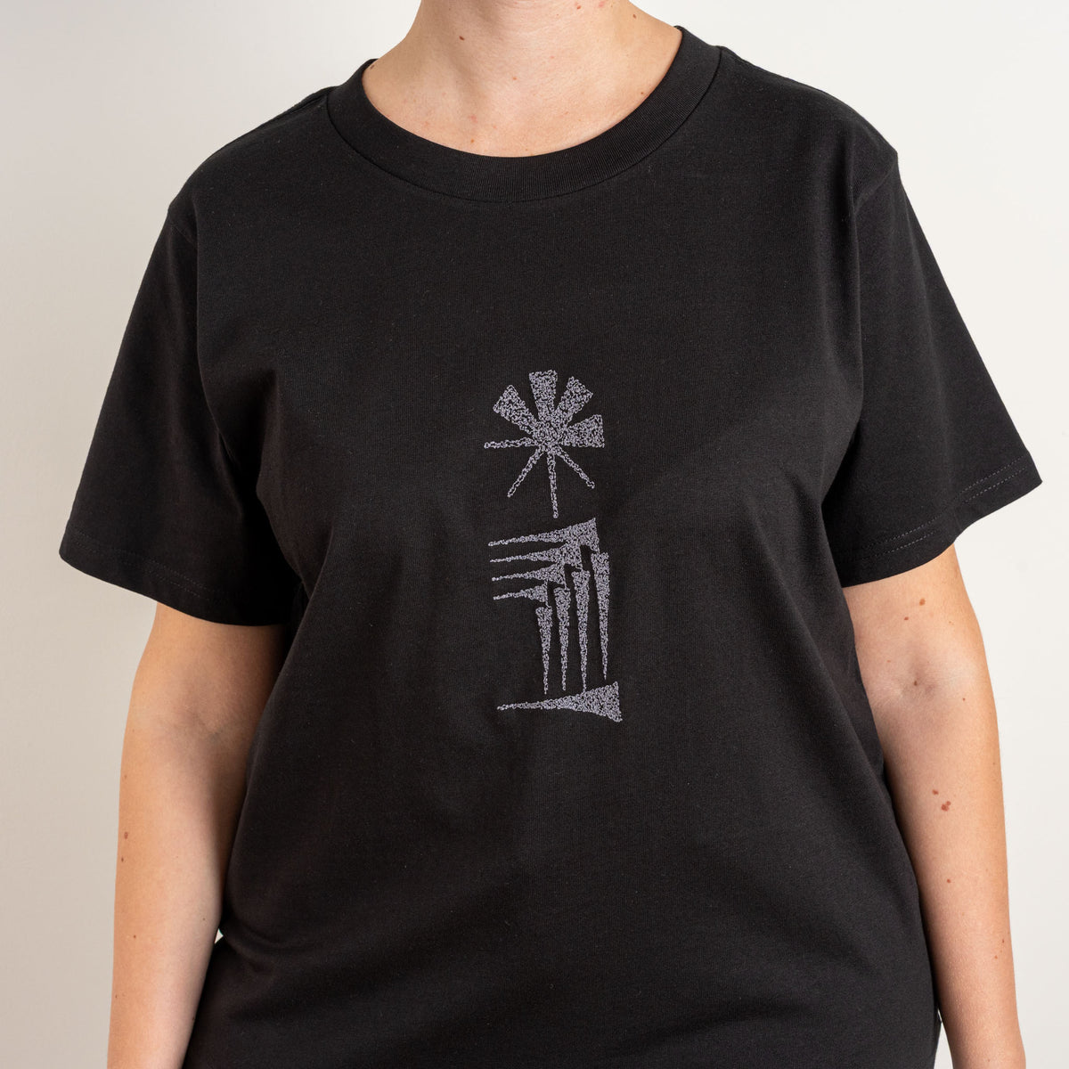 Three-quarter back view of the women’s black Star and House T-shirt.