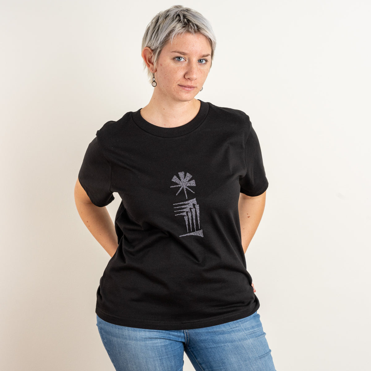 Front view of a model wearing the women’s black Star and House embroidered T-shirt, photographed for Gordina in the Netherlands.