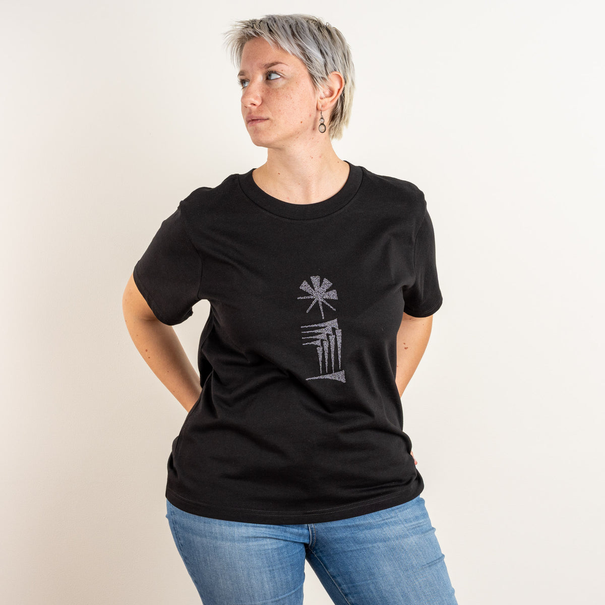 Three-quarter front view of the women’s black Star and House embroidered T-shirt, with the chest motif visible.