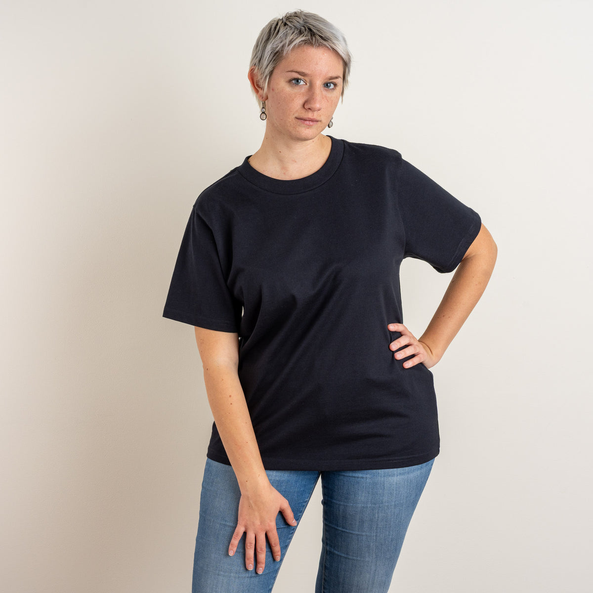 Front view of a woman wearing Gordina’s navy Papyrus T-shirt; the embroidered motif is placed on the back.