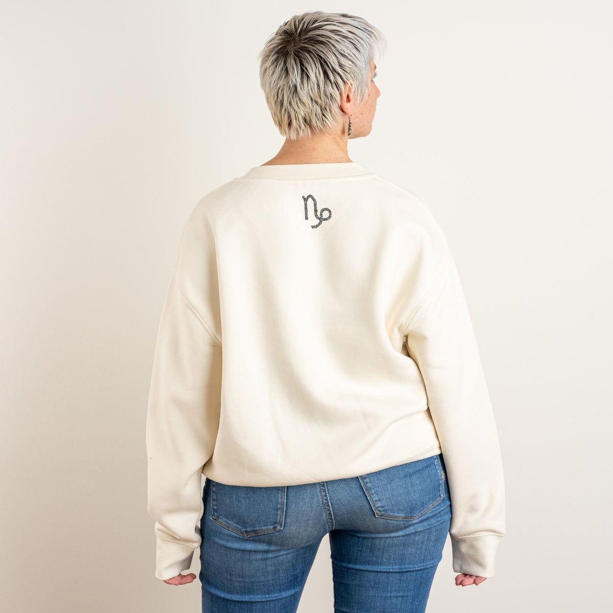 Back view of the bone personalised Relaxed Sweatshirt with Capricorn embroidered on the upper back in black thread