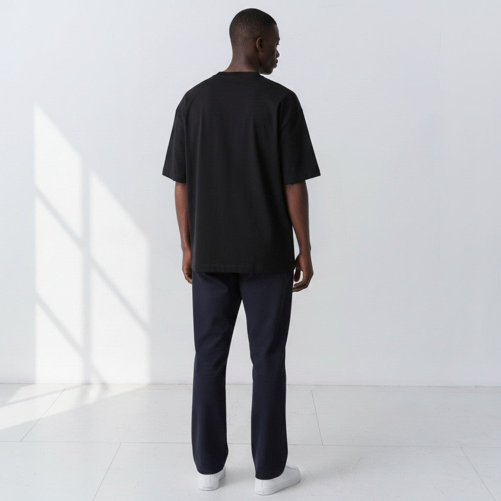Plain back view of a model wearing the Gordina black 5069 oversized cotton T-shirt.