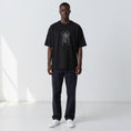 Load image into Gallery viewer, Closer front view of the Gordina The Scarab black oversized T-shirt with grey embroidery.
