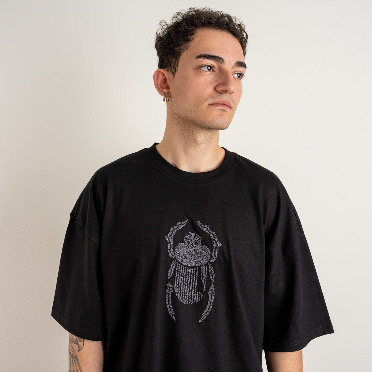 Straight-on upper-body view of the Gordina The Scarab black oversized tee with grey scarab embroidery.