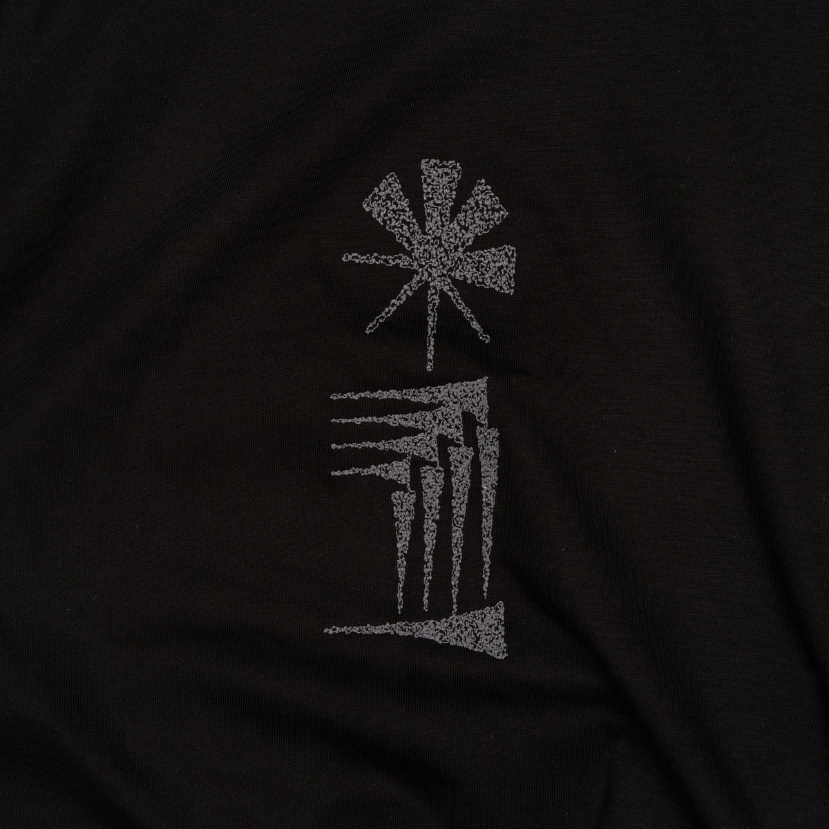 Close-up of the star and house cuneiform embroidery on black cotton