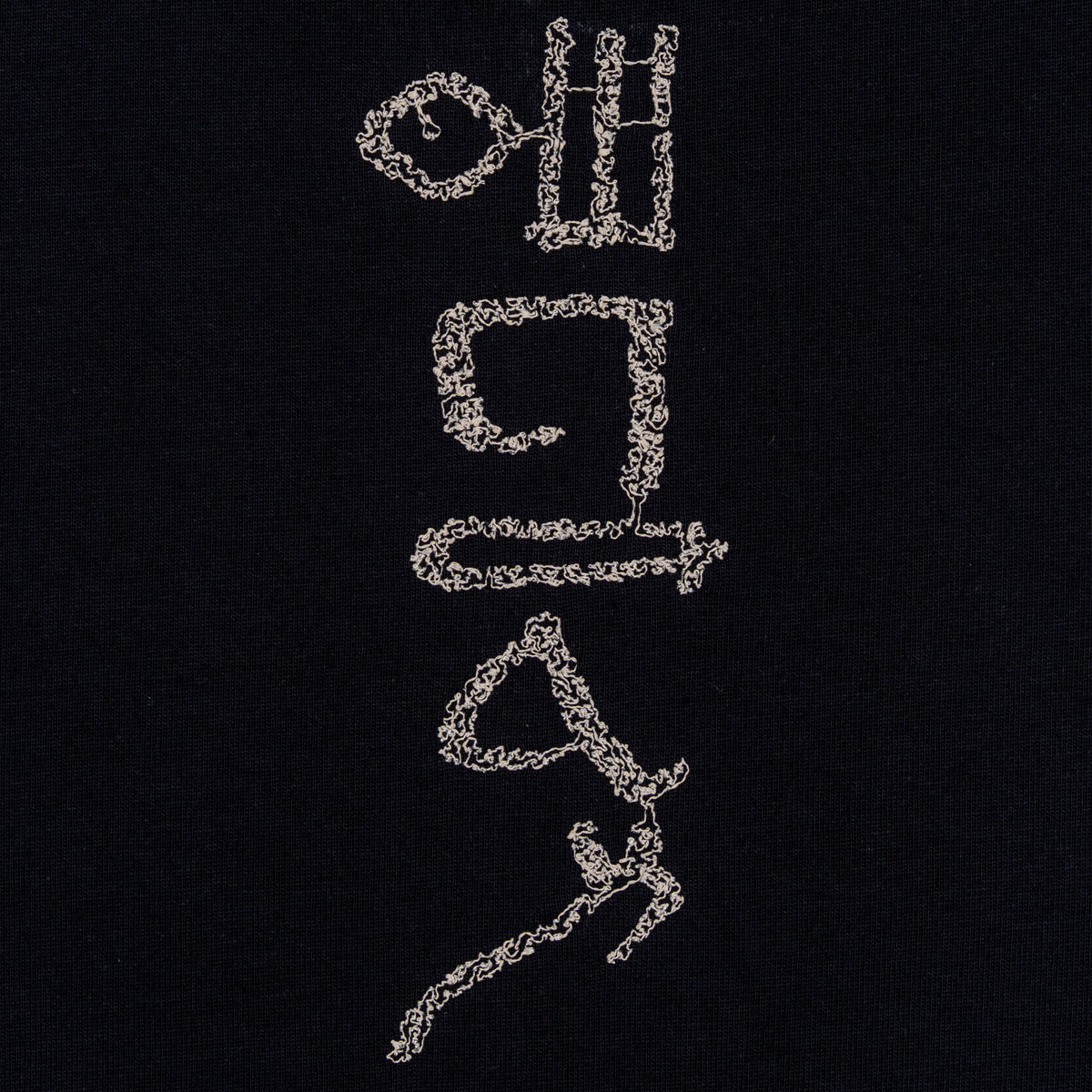 Close-up of the hieroglyphic-style embroidery on The Papyrus women’s navy T-shirt