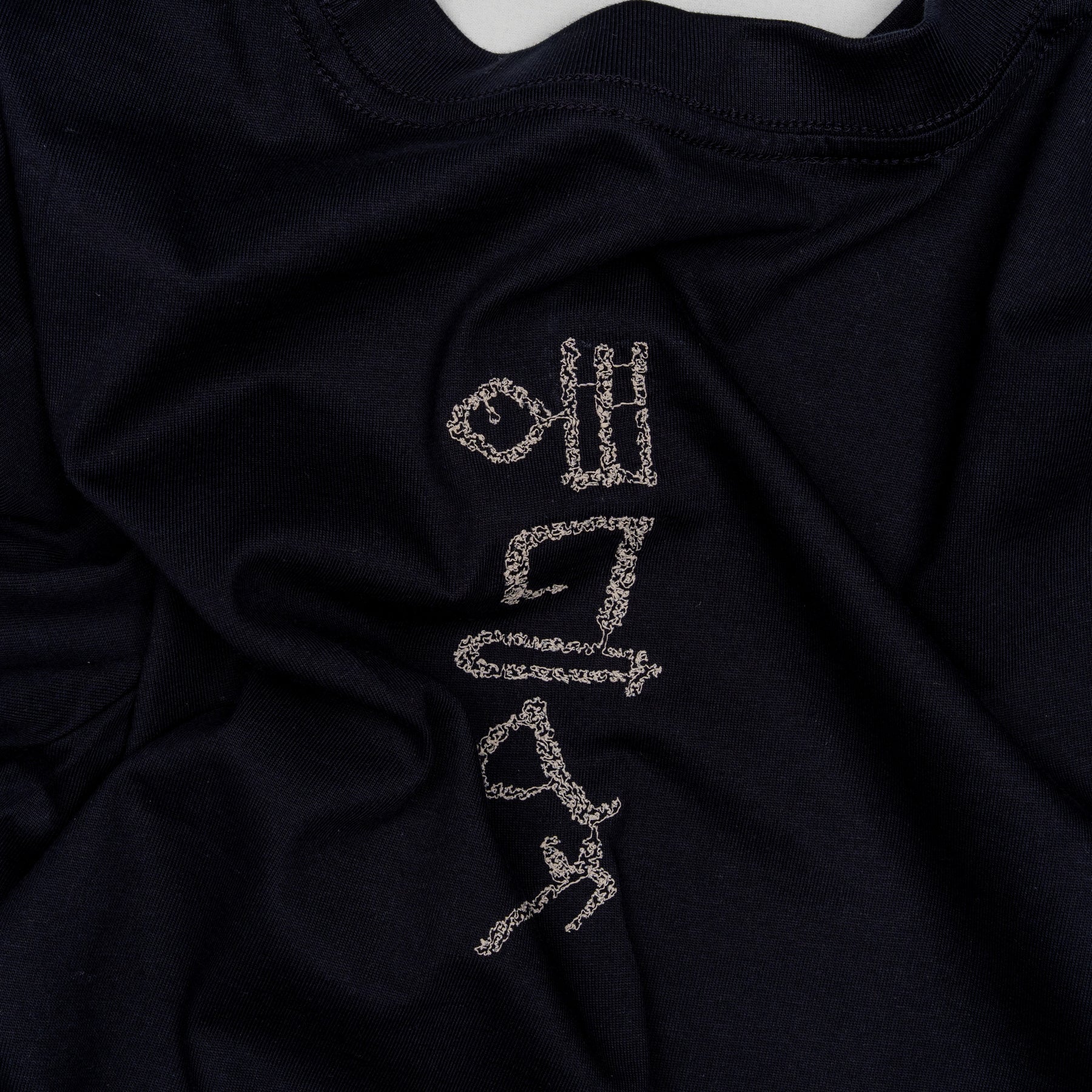 Flat lay of The Papyrus women’s navy T-shirt showing the back motif placement