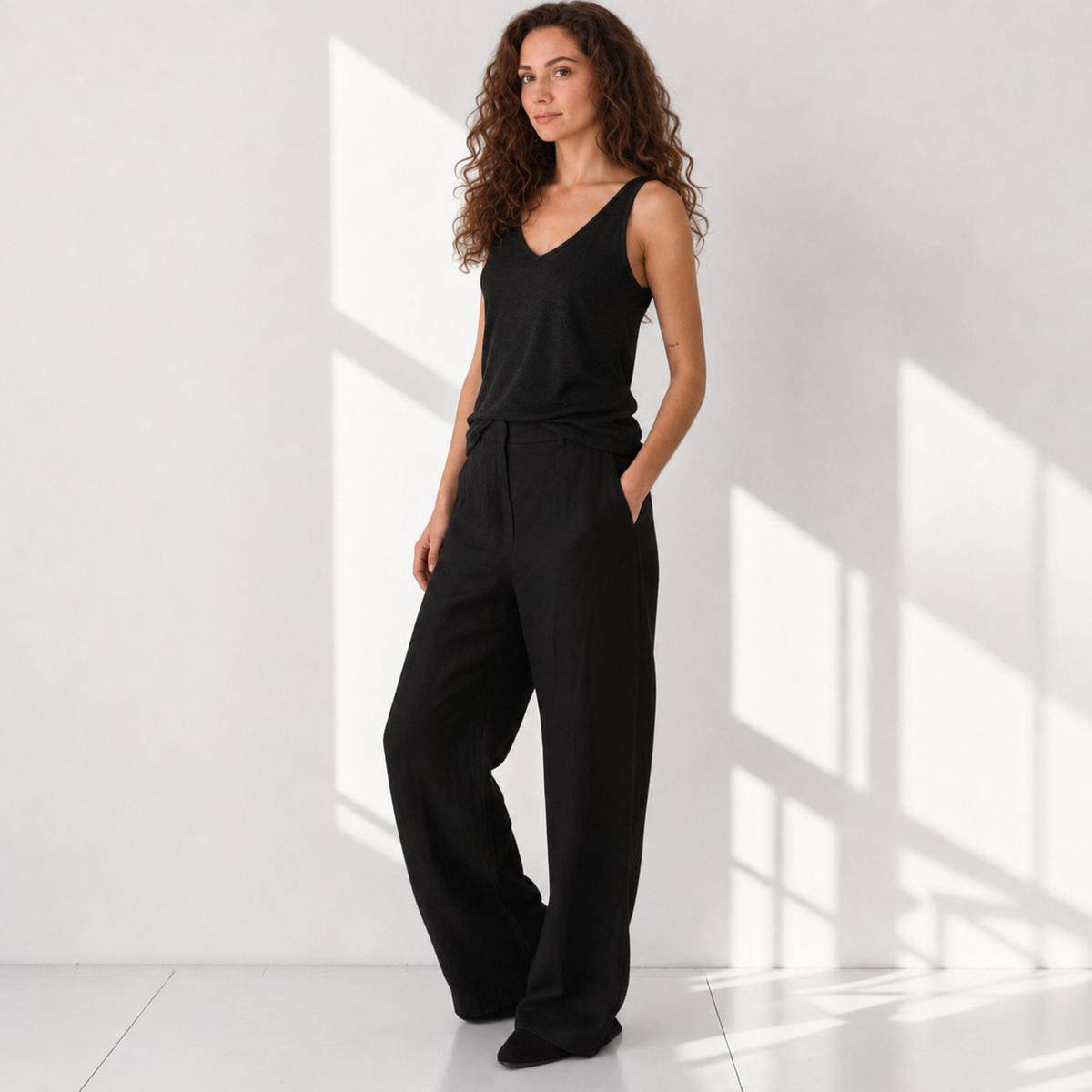 The Poppy Black linen tank top with cream poppy embroidery, model front view