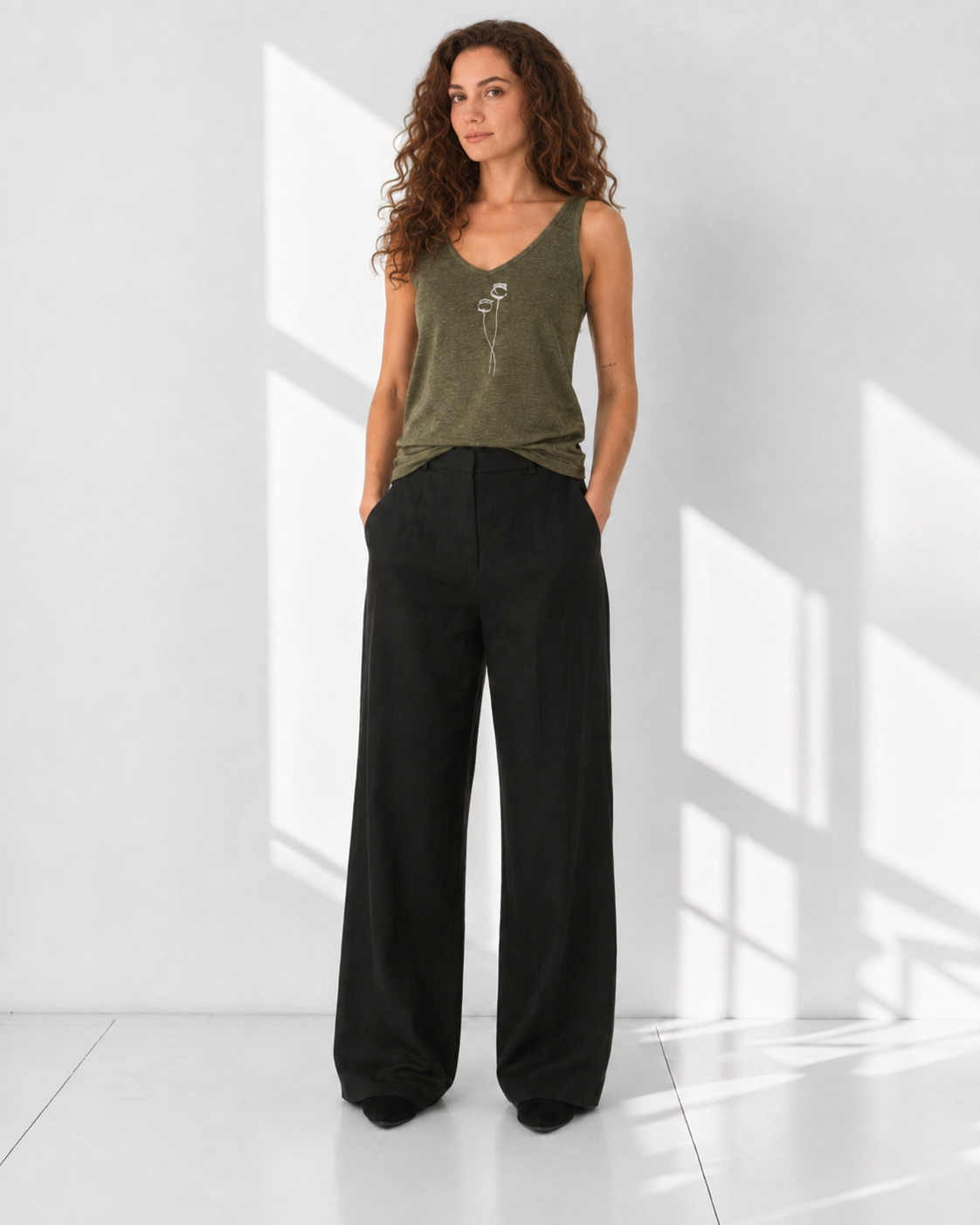 The Poppy Olive Green linen tank top with cream poppy embroidery, model front view