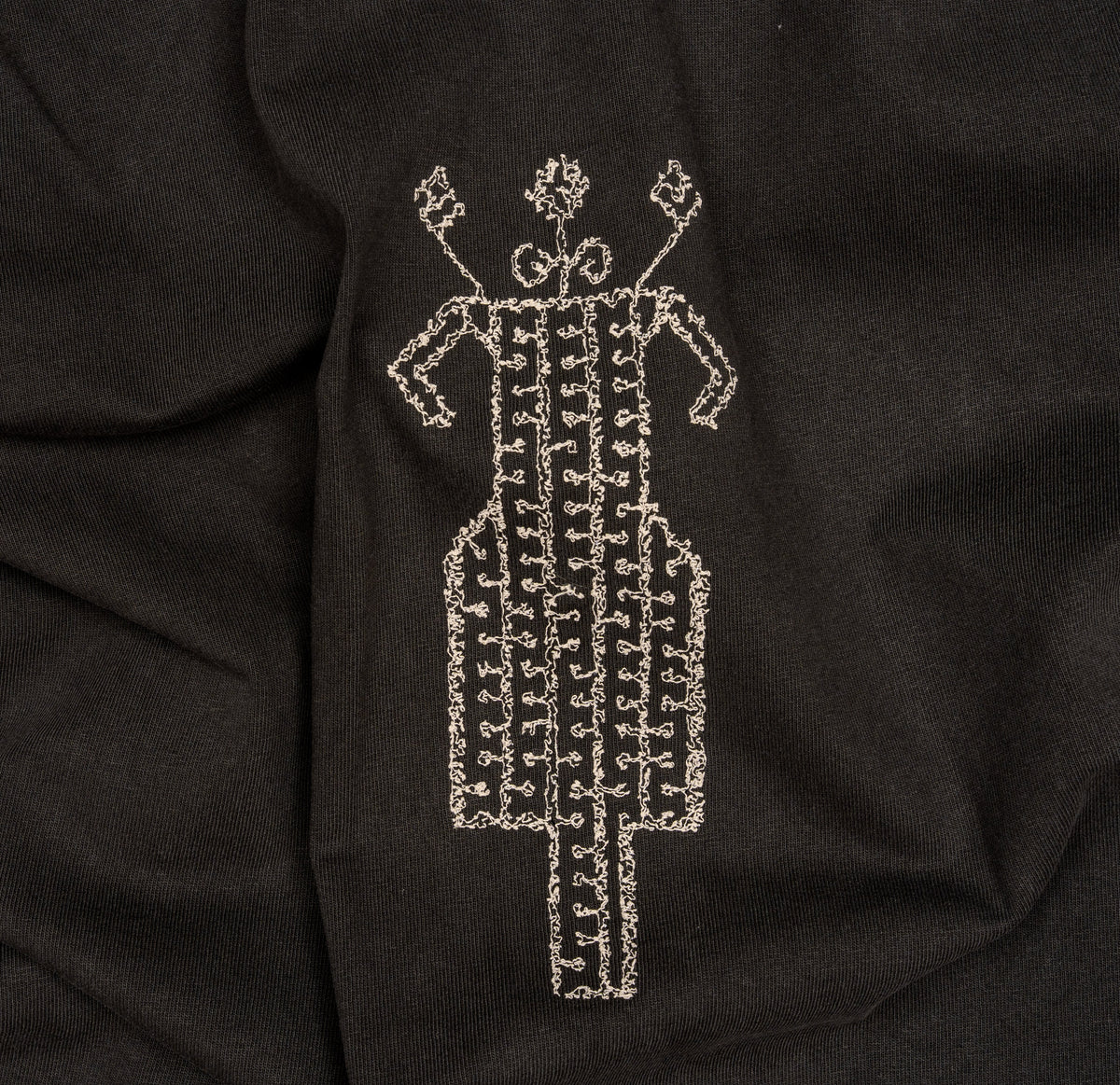 Close-up of cream horse-and-rider embroidery on The Ward Faded Black T-shirt