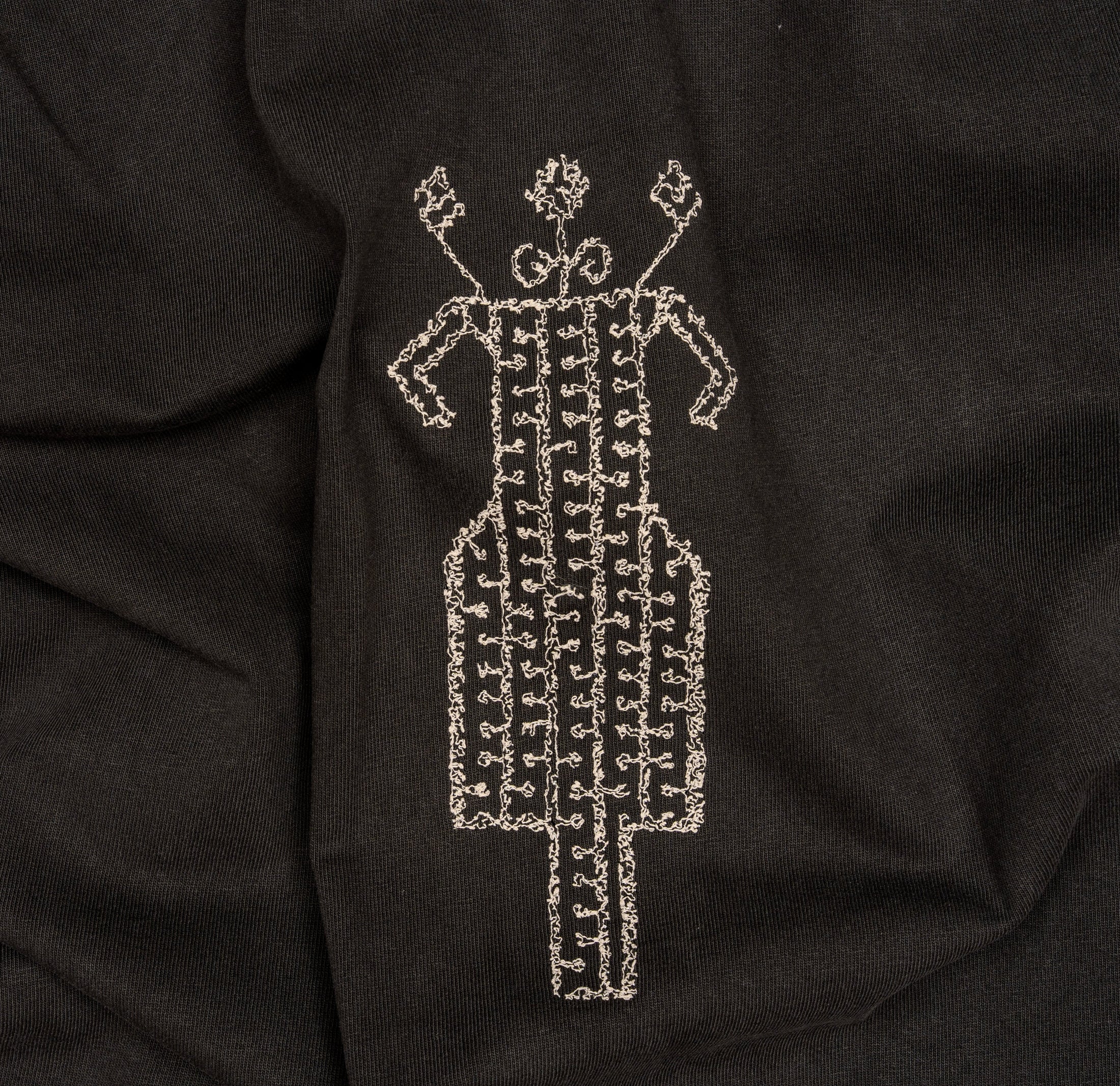 Close-up of cream horse-and-rider embroidery on The Ward Faded Black T-shirt