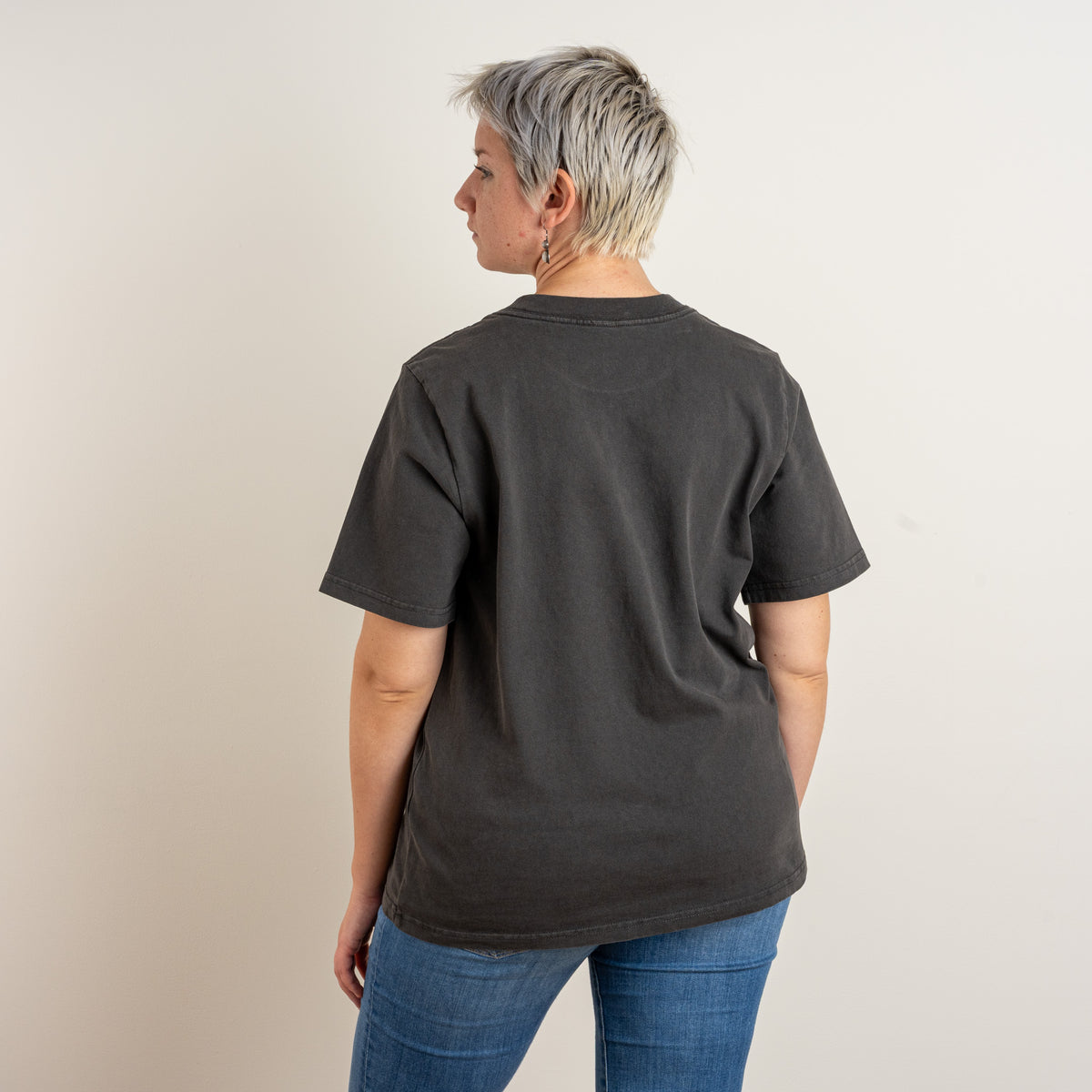 Three-quarter back view of The Ward Faded Black women's T-shirt, showing the plain back and dropped relaxed shoulders.